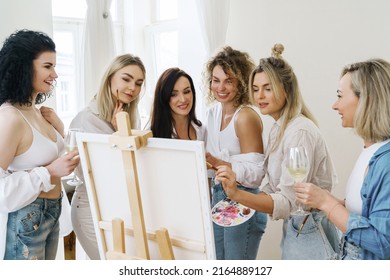 Group Of Young Beautiful Women Paint On Canvas And Drinking White Wine During Party At Home