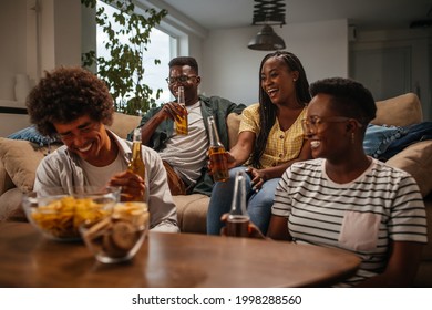 Group of young black friends having beers and snacks in the living room at home - Powered by Shutterstock