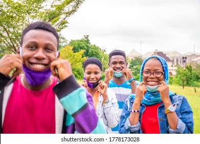 A Group Of Young Black People Wearing Face Masks, With Physical Distancing, Smiling