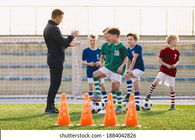 Group of young boys on football training. Kids practicing soccer on grass field. Young man as a soccer coach explaing to players training rules. Children exercising with soccer balls - Powered by Shutterstock