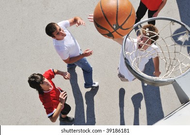 group of young boys who playing basketball outdoor on street with long shadows and bird view perspective - Powered by Shutterstock