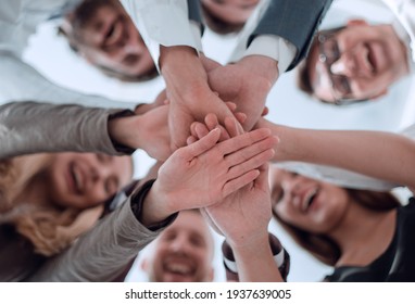 Group Of Young Business Men Clasping Their Hands Together