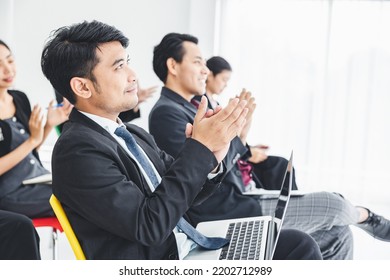 A Group Of Young Business Men Sat Listening Intently At The Presentation And Clapped In Unison. Make The Atmosphere In The Meeting Room Fun.