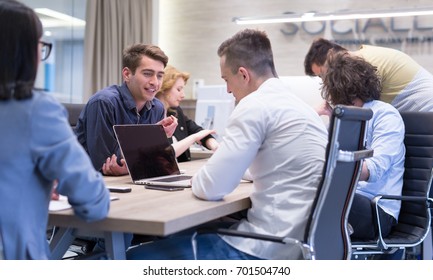 Group of a young business people discussing business plan at modern startup office building - Shutterstock ID 701504740