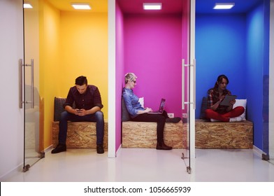 Gruppe junger Geschäftsleute, die sich im modernen Startbüro im kreativen Raum amüsieren, entspannen und arbeiten