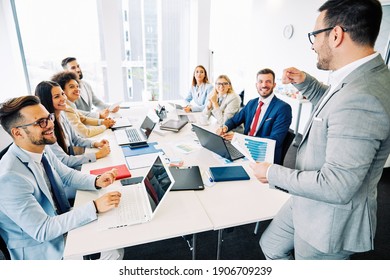 Group of young business people having a meeting in the office, having fun together and laughing - Shutterstock ID 1906709239
