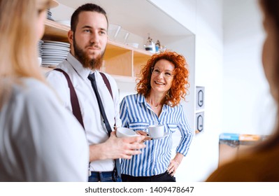 A Group Of Young Business People On Coffee Break In Office Kitchen.