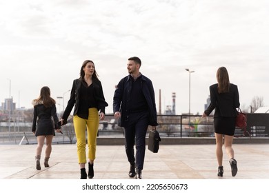 Group of young business people are walking all together in front of their company while talking and smiling - Shutterstock ID 2205650673