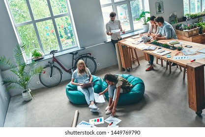 Group of young business people are working together in modern office. Creative people with laptop, tablet, smart phone, notebook. Successful hipster team in coworking. Freelancers. - Shutterstock ID 1449769790