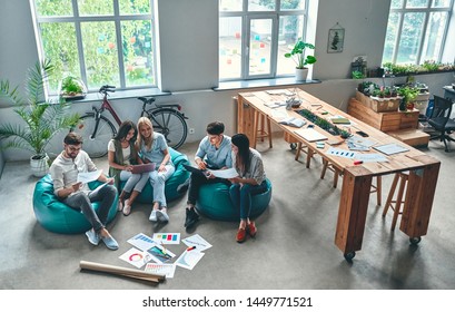 Group of young business people are working together in modern office. Creative people with laptop, tablet, smart phone, notebook. Successful hipster team in coworking. Freelancers. - Shutterstock ID 1449771521