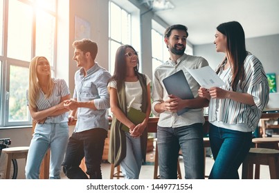 Group of young business people are working together in modern office. Creative people with laptop, tablet, smart phone, notebook. Successful hipster team in coworking. Freelancers. - Shutterstock ID 1449771554