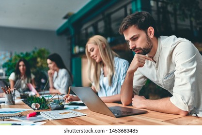 Group of young business people are working together in modern office. Creative people with laptop, tablet, smart phone, notebook. Successful hipster team in coworking. Freelancers. - Shutterstock ID 1453683485