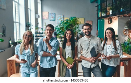 Group of young business people are working together in modern office. Creative people with laptop, tablet, smart phone, notebook. Successful hipster team in coworking. Freelancers. - Shutterstock ID 1453683488