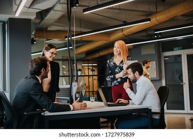 Group of young business people working and communicating together in the creative office - Shutterstock ID 1727975839