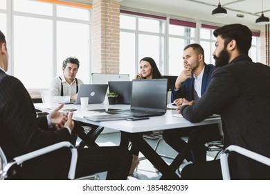 Group of young business people working and communicating while sitting at the office desk together with colleagues sitting. business meeting - Shutterstock ID 1854829039