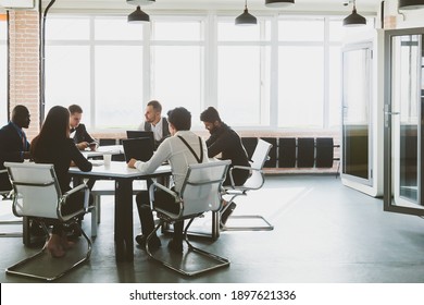 Group of young business people working and communicating while sitting at the office desk together with colleagues sitting. business meeting - Powered by Shutterstock