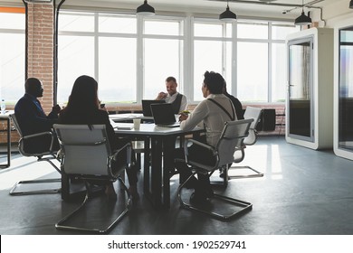 Group Of Young Business People Working And Communicating While Sitting At The Office Desk Together With Colleagues Sitting. Business Meeting