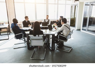 Group of young business people working and communicating while sitting at the office desk together with colleagues sitting. business meeting