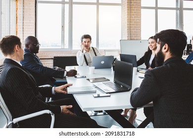 Group of young business people working and communicating while sitting at the office desk together with colleagues sitting. business meeting - Shutterstock ID 2091831718