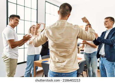 Group Of Young Business Workers Smiling And Clapping. Young Businessman Doing Strong Gesture With Arms On Back View At The Office.