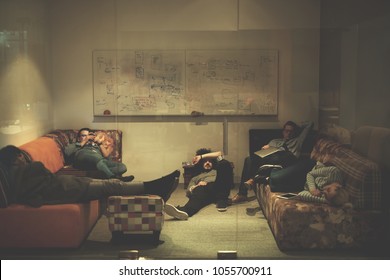 group of young casual software developer sleeping on  sofa during a work break in creative startup office