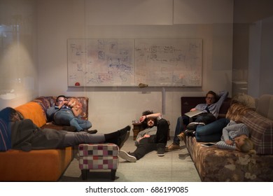group of young casual software developer sleeping on  sofa during a work break in creative startup office