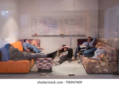 group of young casual software developer sleeping on  sofa during a work break in creative startup office