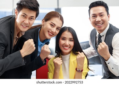 Group Of Young Cheerful Asian Business Team Working Together In The Office. Office Business People With Positive Energy Looking At Camera With Smiley Face. Start Up Business Strong Teamwork.