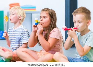 Group of young children making breathing exercises during physical therapy session. Kids in group physiotherapy.