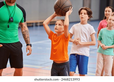 A group of young children standing around a basketball as their teacher instructs them in a bright, lively classroom setting. - Powered by Shutterstock