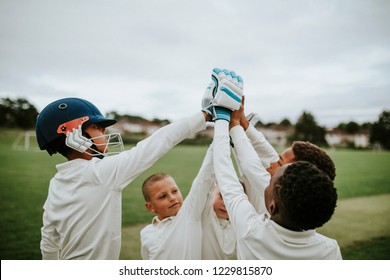 Group of young cricketers doing a high five - Powered by Shutterstock