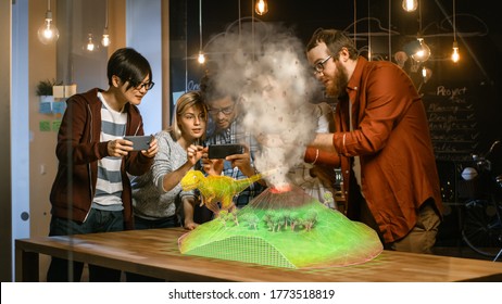 Group Of Young Developers Look At Dinosaur And Volcano Eruption In Augmented Reality Through Smartphone. They're Working On The New Virtual Reality Game Or Studying History And Geology.