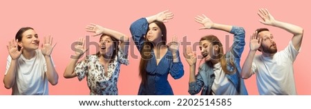 Group of young different people, emotional men and girls face the transparent glass isolated on pink background. Sales, human rights, social gathering, ad. Models leaning against glass