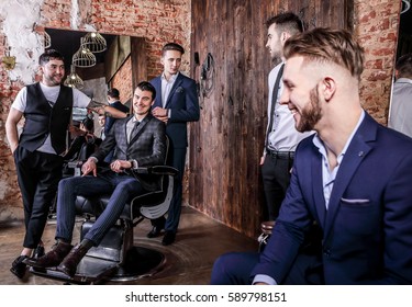 Group Of Young Elegant Positive Mens Pose In Interior Of Barbershop.