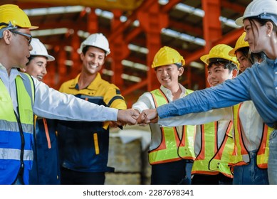 Group of young Engineer United stack hands or join hand teamwork together with Spirit diversity solidarity team Partner in metal sheet factory. Joins hands together teamwork meetings empower. - Powered by Shutterstock