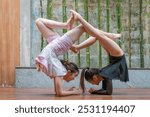 A group of young female acrobats is posing. Gymnasts perform in a studio against a Japanese home-style background to demonstrate flexibility and stretch the concept of a circus show. Asian teenager.