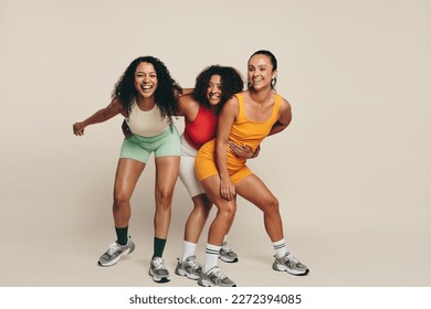 Group of young female athletes laughing and having fun in fitness clothing, celebrating their love for sport and exercise. Happy young sportswomen demonstrating their commitment to a healthy lifestyle - Powered by Shutterstock