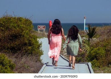 A Group Of Young Female Children Of Mexican Descent Walk On A Board Walk Toward The Beach In Jacksonville Florida During The Summer