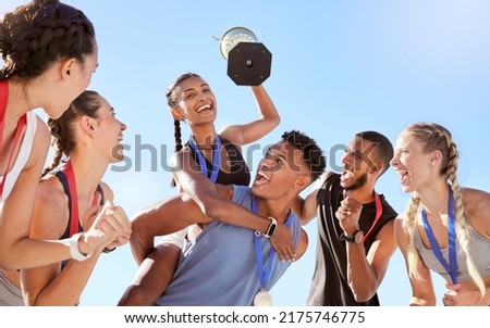 Group of a young fit diverse team of athletes celebrating their victory with a golden trophy. Team of active happy athletes rejoicing after winning an award or trophy after a competitive race