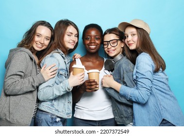 Group of young five female friends of different nationalities holding a cups of coffee to go over blue background. Lifestyle, friendship and people concept. - Shutterstock ID 2207372549
