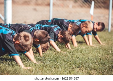  Group of young football players perform warm-up exercises before football training. Young players  doing push-up exercises outdoor. - Powered by Shutterstock