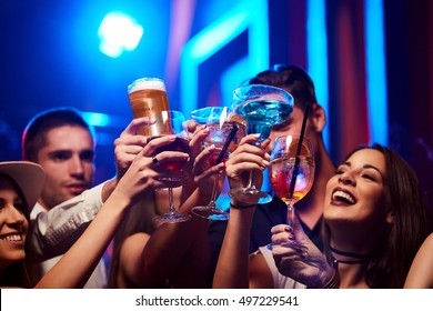 Group of Young friendly people toasting in night club or bar - Powered by Shutterstock