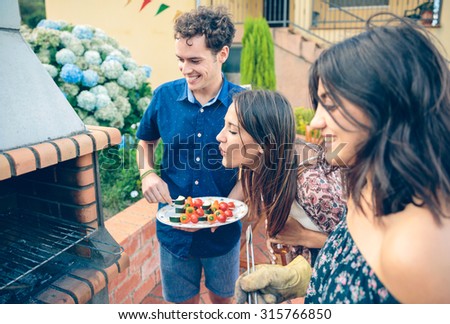 Gruppe von Freunden, die bei einem Sommergrill kochen.