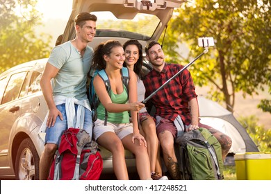 
Group of young friends in countryside on camping trip taking selfie using smartphone - Powered by Shutterstock