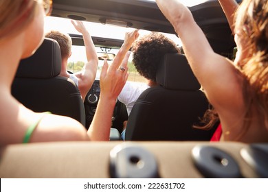 Group Of Young Friends Dancing In Back Of Open Top Car