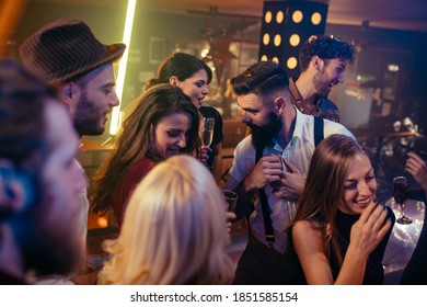 Group of young friends dancing together in the nightclub
