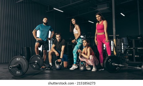 Group of young friends doing sports, training at gym indoors. Friends posing, resting, cooling down after hard workout. Concept of health, sportive lifestyle, fitness, beauty, body care, diet - Powered by Shutterstock