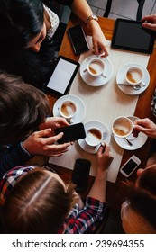 Group Of Young Friends Drinking Coffee In Cafe. View From Above