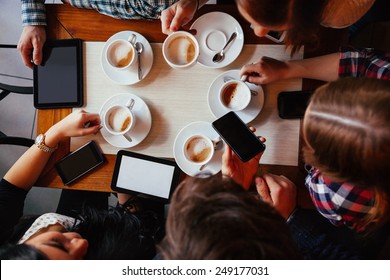 Group Of Young Friends Drinking Coffee In Cafe. View From Above