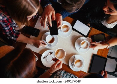 Group Of Young Friends Drinking Coffee In Cafe. View From Above